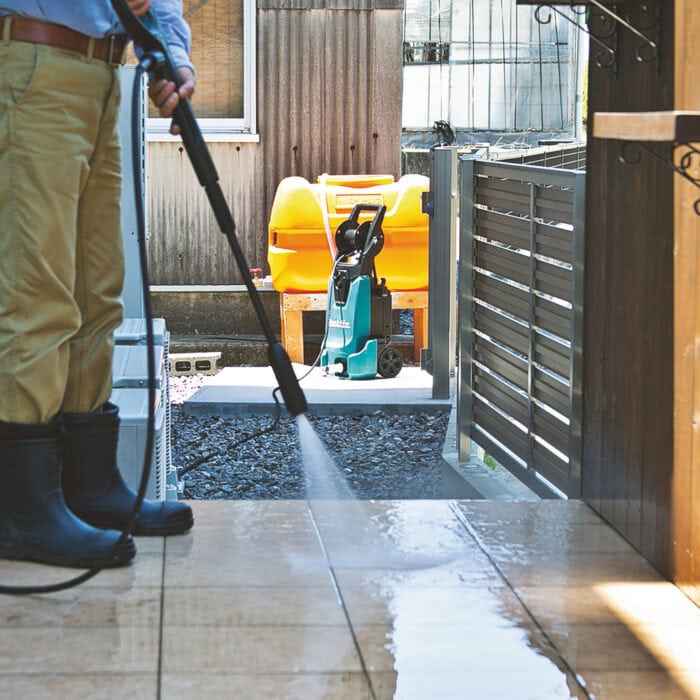 Makita Elektro-Hochdruckreiniger HW1300 in Aktion – entfernt kraftvoll Schmutz von Terrassen, Fahrzeugen, Gartenmöbeln und Pflastersteinen.