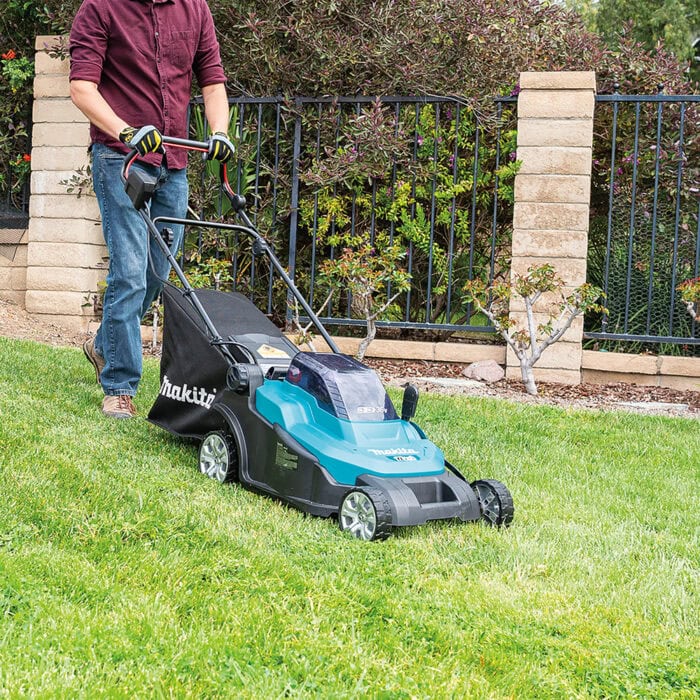 Makita Akku-Rasenmäher DLM432Z beim Mähen im Garten